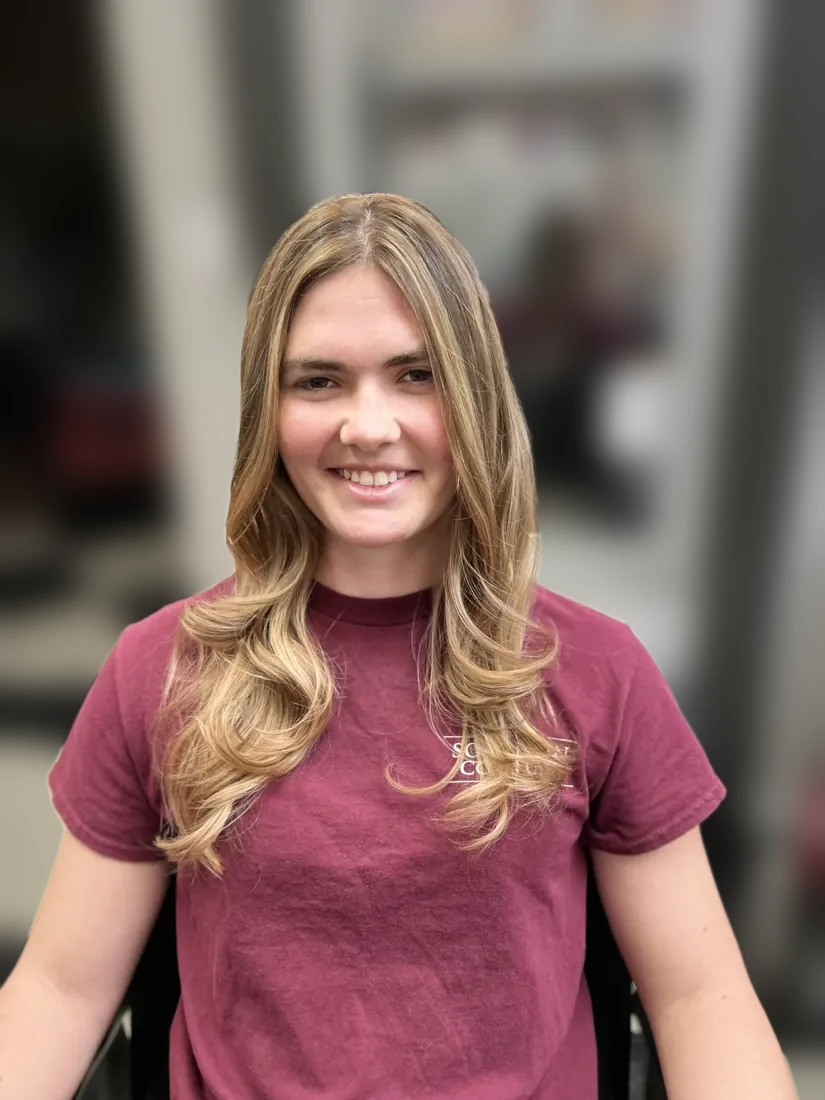 Smiling client with soft blonde balayage waves