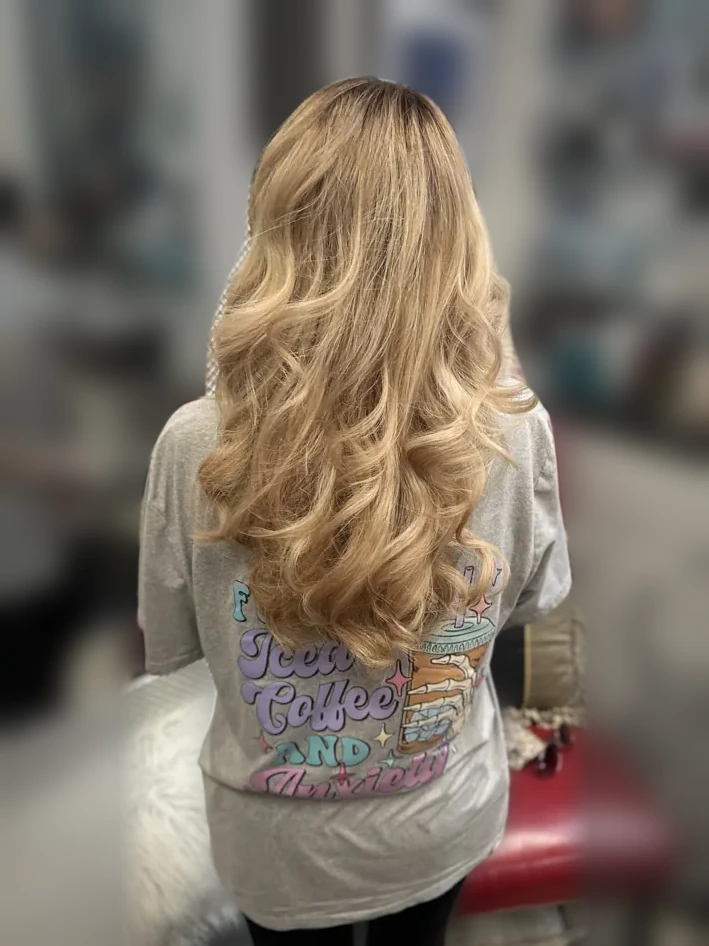 Long buttery blonde curls, back view in the salon
