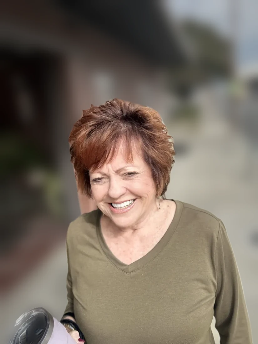 Laughing client with a coppery red shag outside the shop