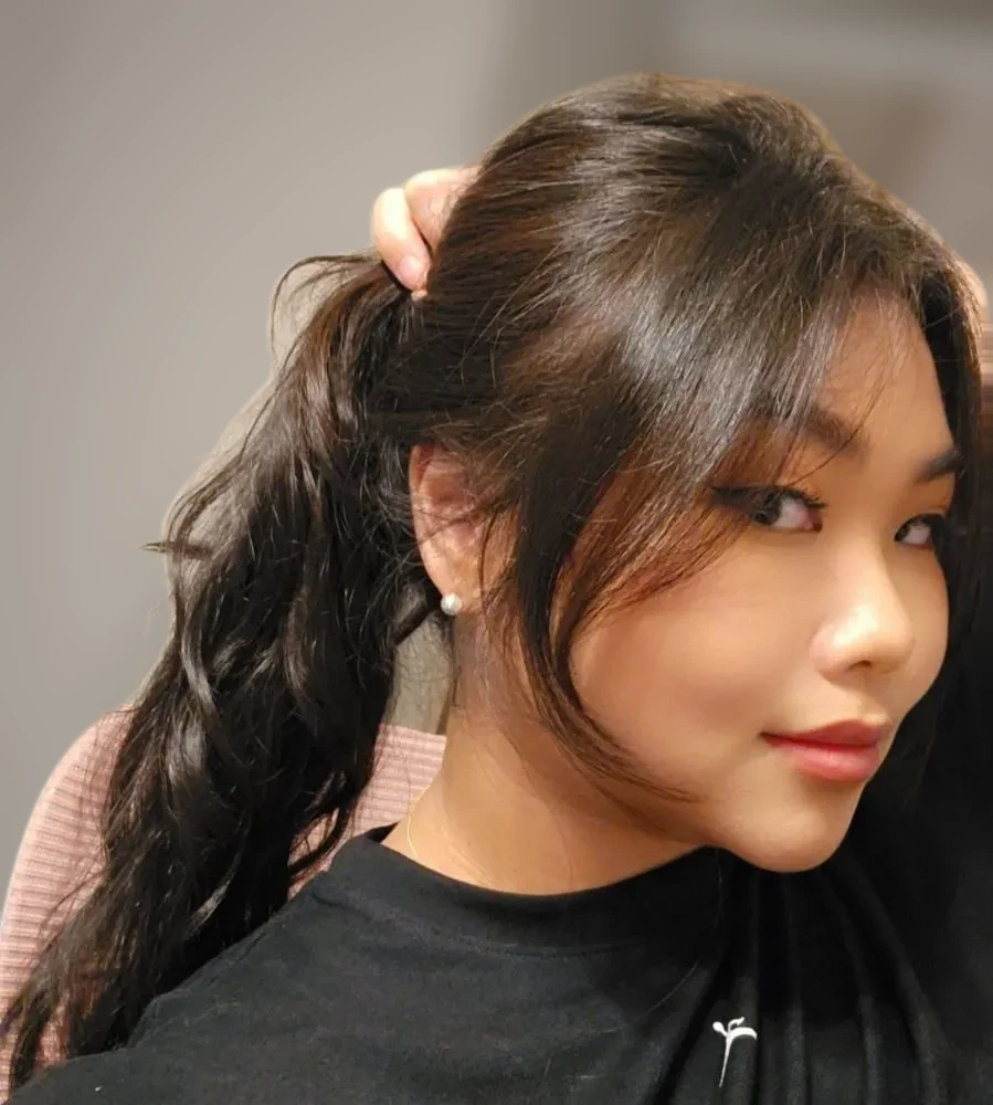 Client selfie with a wavy ponytail and face-framing pieces