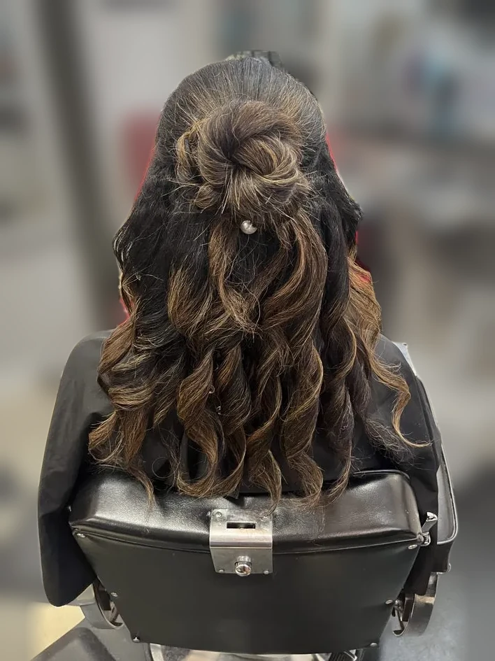 Half-up bun with cascading highlighted curls